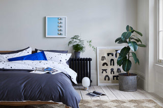 schlafzimmer mit gepunkteter und dunkelgrauer bettwäsche 